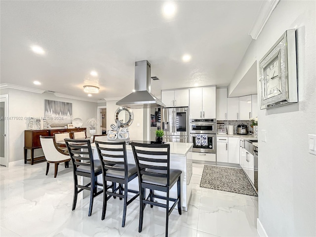 kitchen featuring white cabinetry, a kitchen breakfast bar, stainless steel appliances, light tile floors, and island range hood