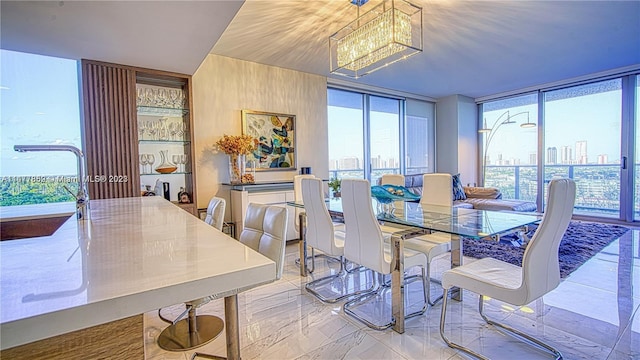 dining room with light tile flooring, a healthy amount of sunlight, and a notable chandelier