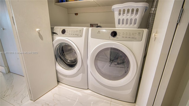 clothes washing area featuring light tile flooring, separate washer and dryer, and hookup for a washing machine