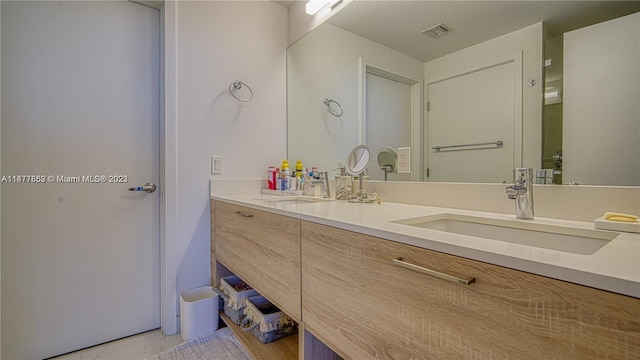 bathroom featuring tile flooring, oversized vanity, and dual sinks