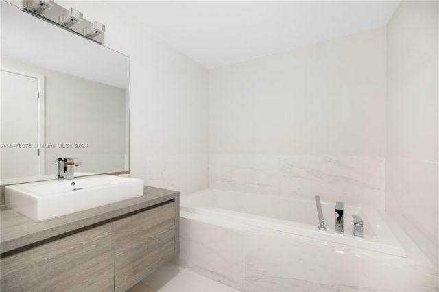 bathroom with tile floors, tiled tub, and vanity