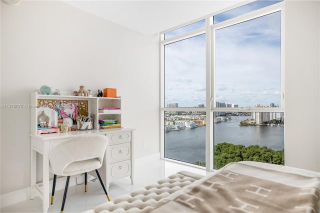 office with a water view, plenty of natural light, floor to ceiling windows, and light tile floors