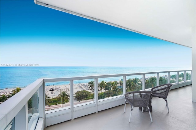 balcony featuring a beach view and a water view