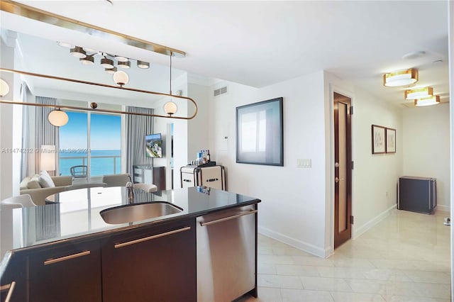 kitchen featuring light tile floors, stainless steel dishwasher, sink, and a water view