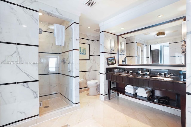 bathroom with toilet, double sink vanity, a shower with door, tile walls, and backsplash