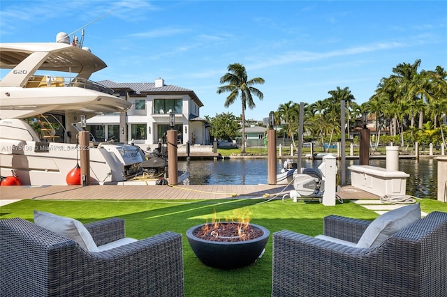 exterior space featuring a water view, a fire pit, and a yard