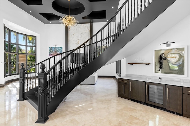 staircase with marble finish floor, a high ceiling, and baseboards