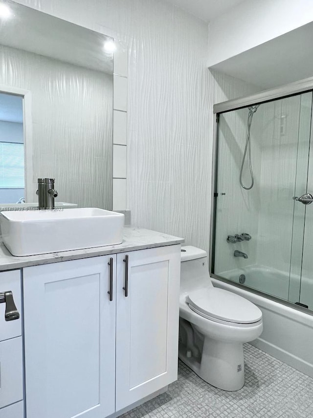 full bathroom featuring tile patterned flooring, vanity, toilet, and shower / bath combination with glass door