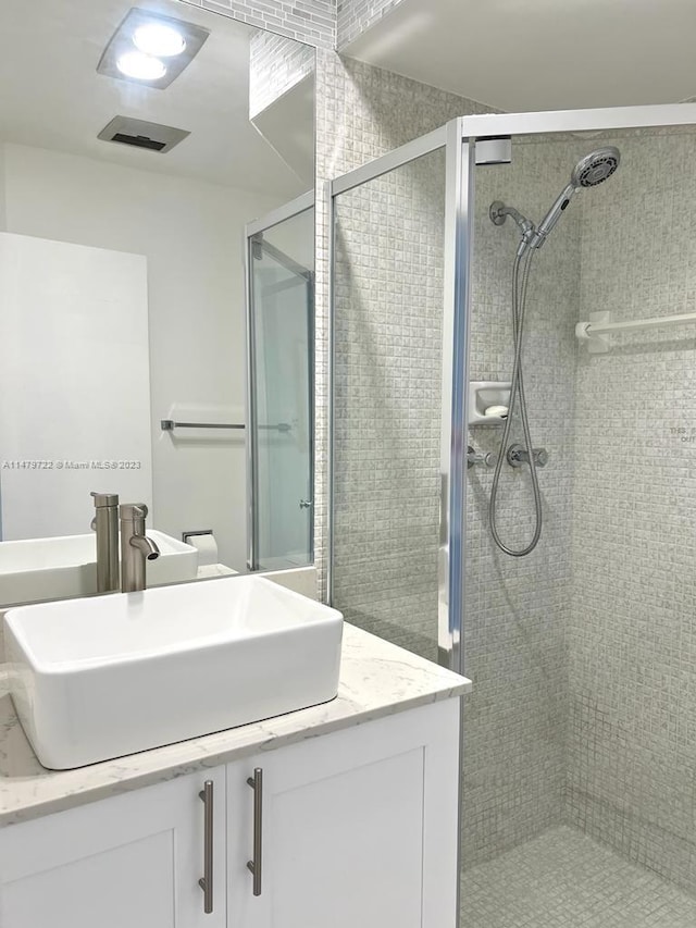 bathroom with vanity and a shower with shower door