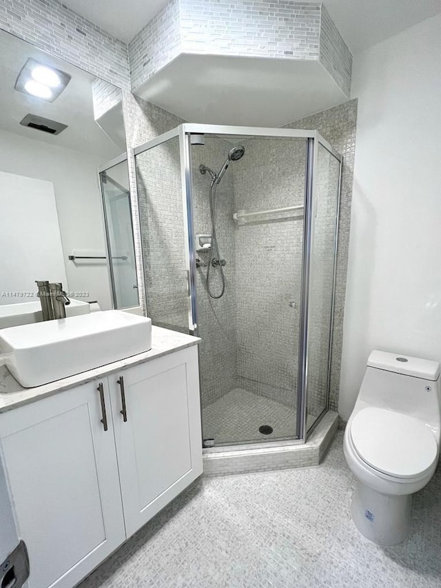 bathroom featuring vanity, toilet, and walk in shower