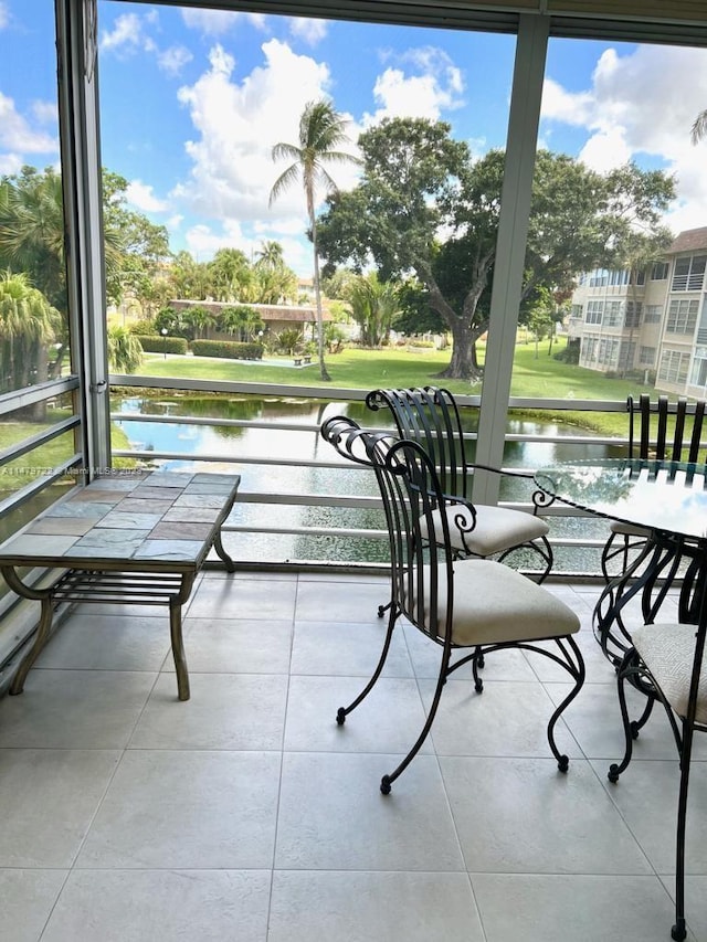 sunroom featuring a water view and a wealth of natural light