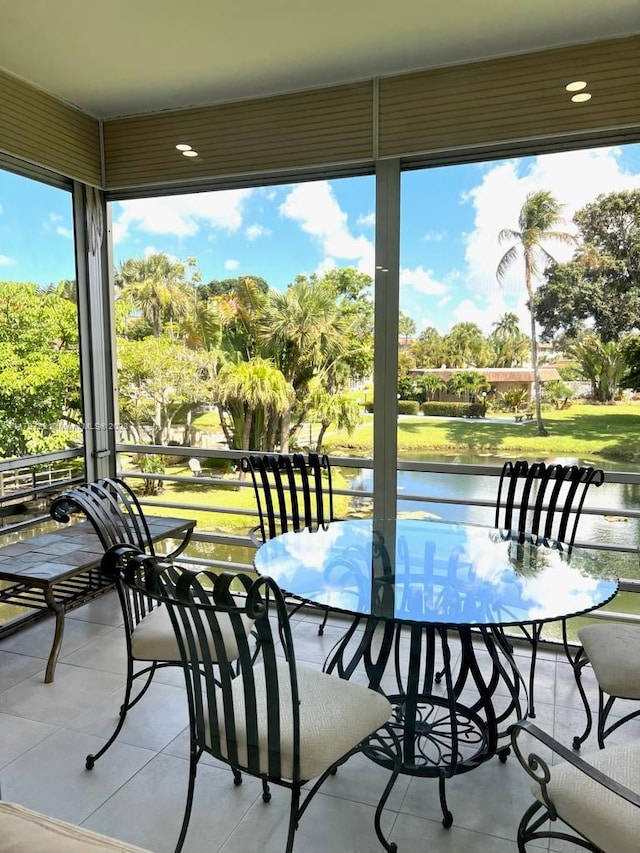 sunroom / solarium featuring a water view