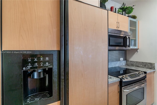2775 NE 187th St Unit 516, Aventura, FL 33180 - kitchen featuring light stone countertops, glass insert cabinets, and appliances with stainless steel finishes