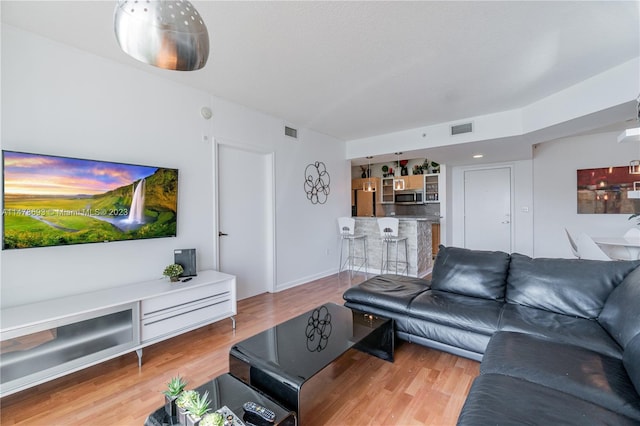 2775 NE 187th St Unit 516, Aventura, FL 33180 - living room featuring baseboards, visible vents, and wood finished floors