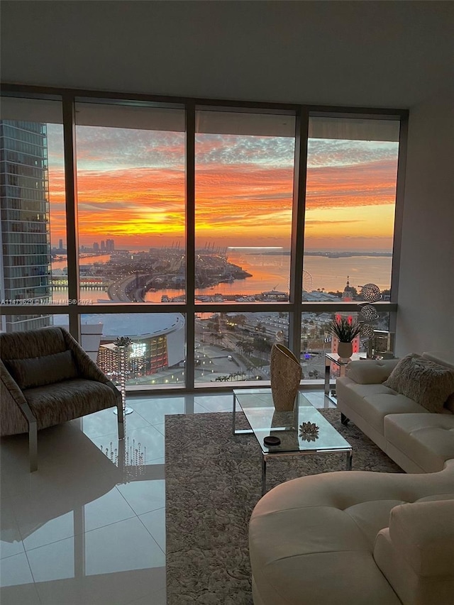 living room with light tile floors, plenty of natural light, expansive windows, and a water view