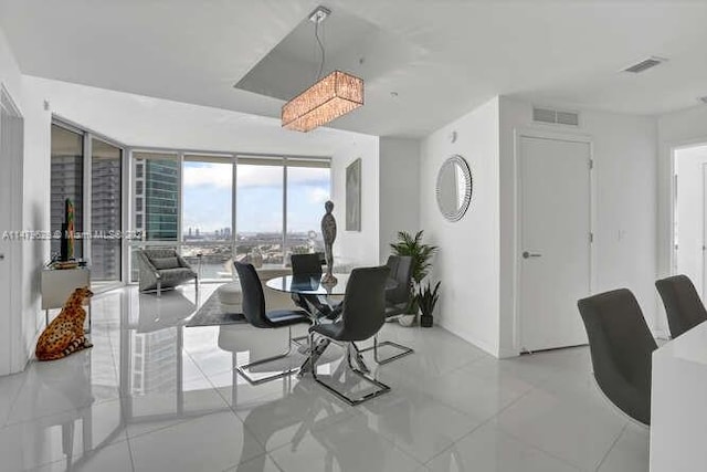 dining area featuring a wall of windows and light tile floors