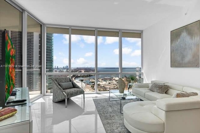 living room featuring light tile flooring, a healthy amount of sunlight, and a wall of windows