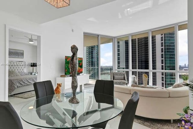 dining space with expansive windows and ceiling fan