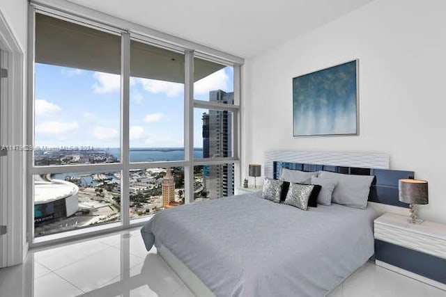 bedroom featuring light tile floors, expansive windows, and multiple windows