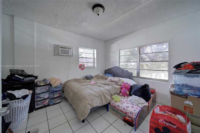 tiled bedroom with a wall mounted AC and a textured ceiling