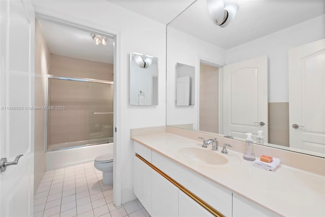 full bathroom with tile floors, toilet, bath / shower combo with glass door, and vanity