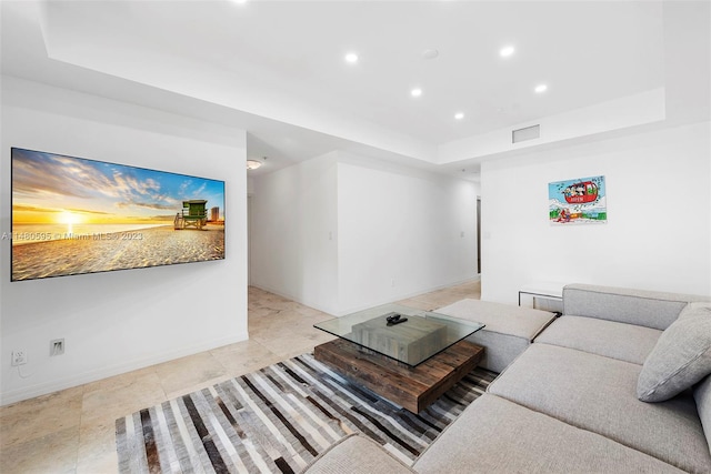 tiled living room featuring a raised ceiling