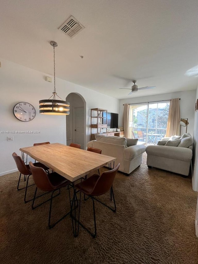 dining area featuring dark colored carpet and ceiling fan