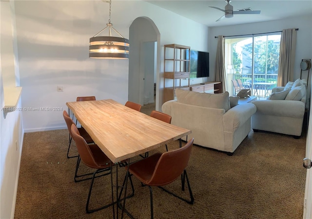 dining area with dark carpet and ceiling fan