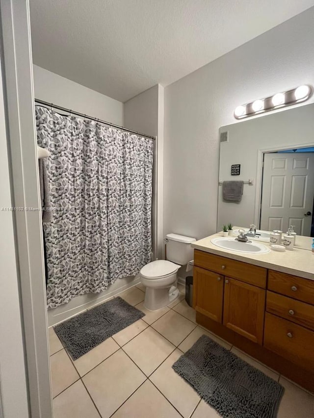 bathroom featuring vanity, toilet, a textured ceiling, a shower with curtain, and tile patterned flooring