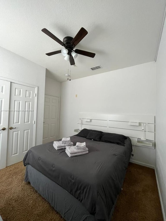 carpeted bedroom featuring a textured ceiling and ceiling fan