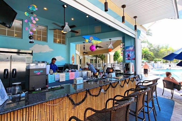 view of patio featuring ceiling fan and an outdoor bar