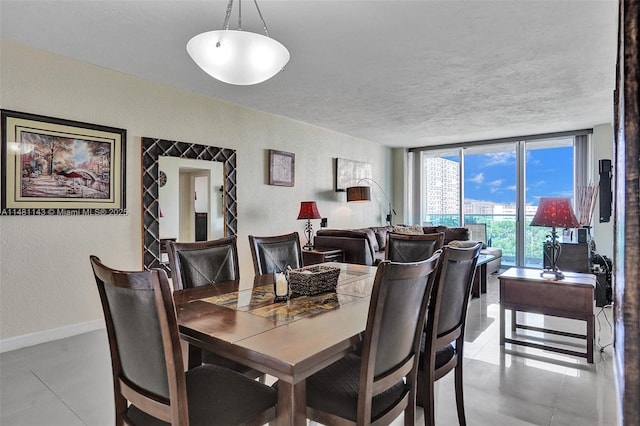 tiled dining space with a textured ceiling and a wall of windows