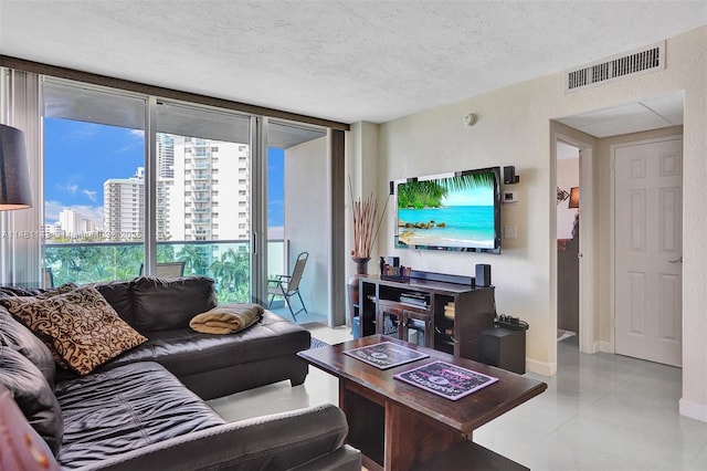 living room featuring floor to ceiling windows, light tile patterned floors, and a textured ceiling