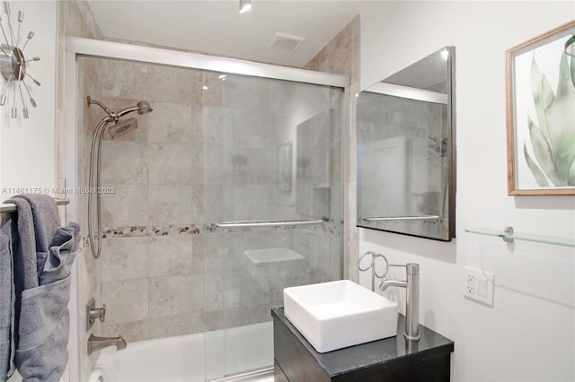 bathroom featuring vanity and bath / shower combo with glass door