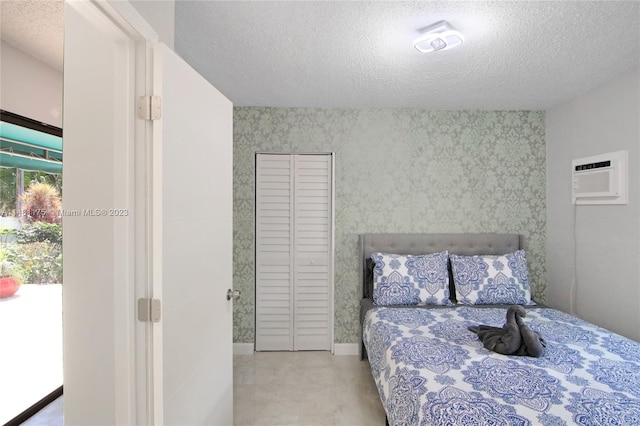 bedroom featuring an AC wall unit and a textured ceiling