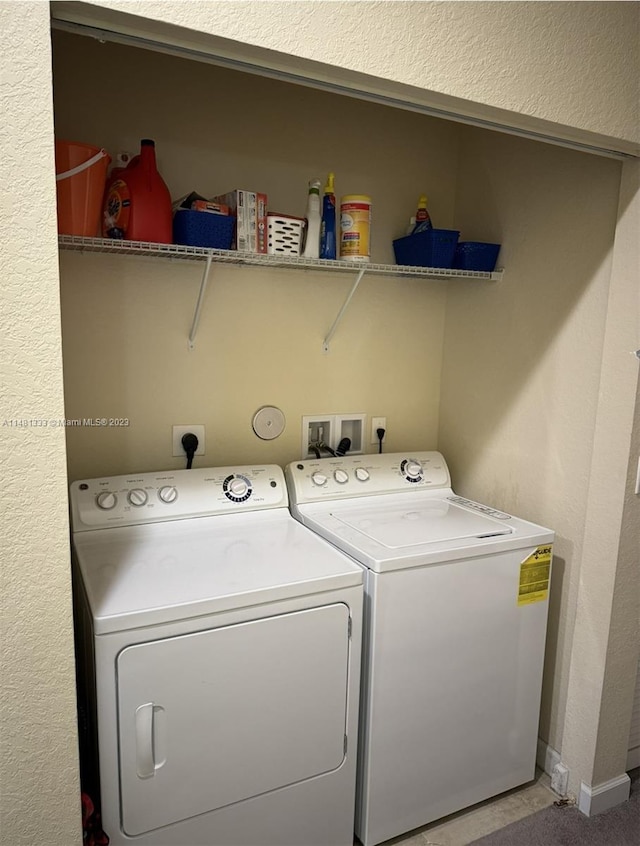 washroom with electric dryer hookup, hookup for a washing machine, and washer and clothes dryer