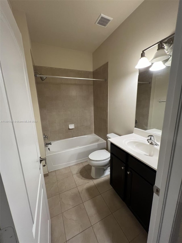 full bathroom featuring vanity with extensive cabinet space, tiled shower / bath, toilet, and tile floors