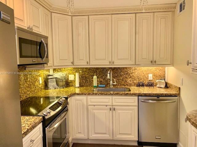 kitchen with backsplash, sink, stainless steel appliances, white cabinets, and dark stone counters