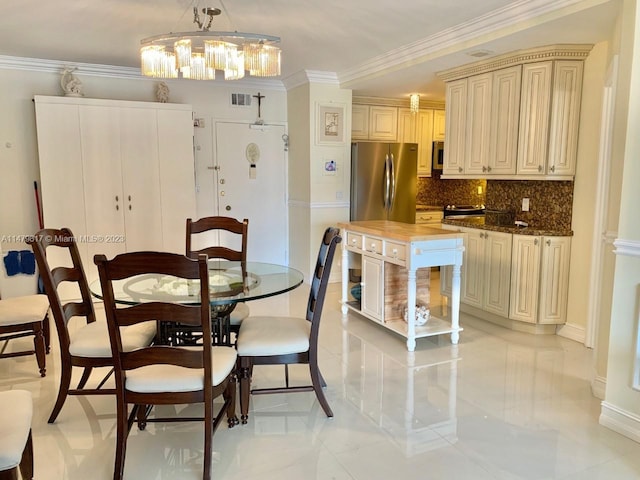 dining room featuring an inviting chandelier, ornamental molding, and light tile floors