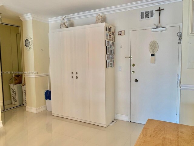 interior space featuring light tile flooring and crown molding