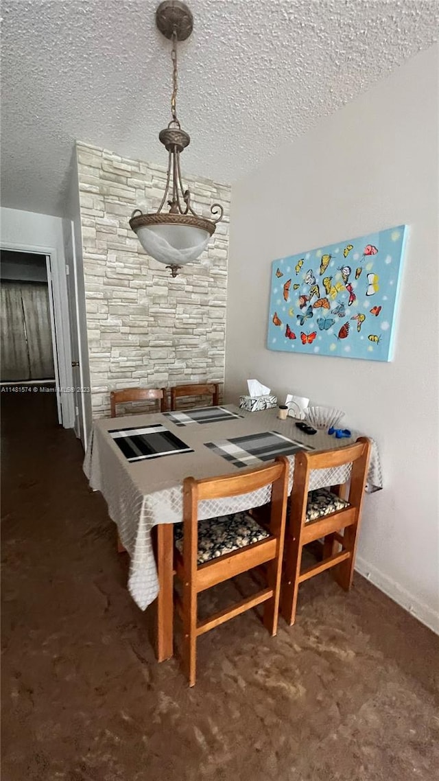 dining space featuring dark carpet and a textured ceiling