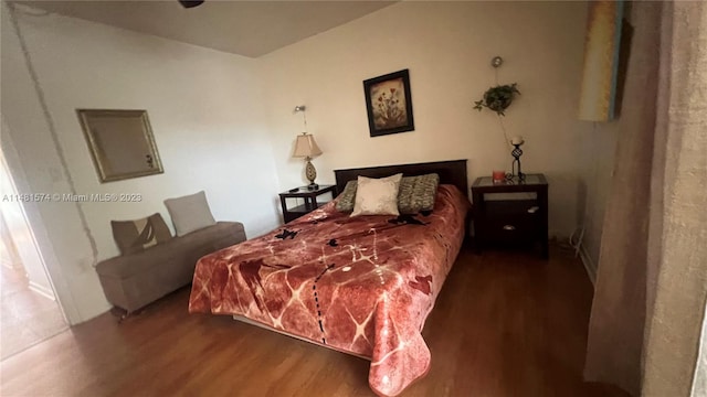 bedroom with dark hardwood / wood-style flooring