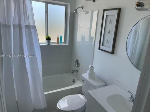 full bathroom featuring toilet, vanity, and shower / tub combo with curtain