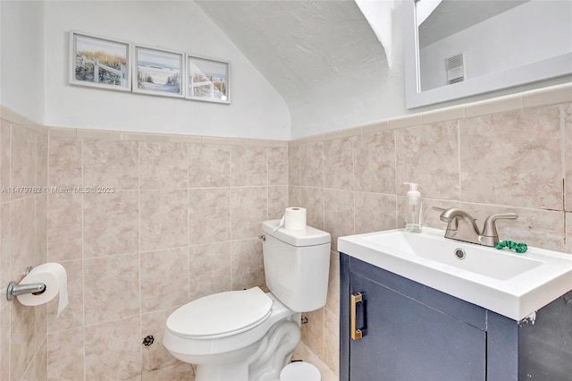 bathroom featuring tile walls, tasteful backsplash, vaulted ceiling, toilet, and vanity