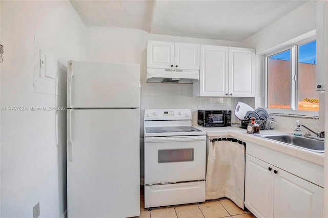 kitchen with backsplash, white appliances, light tile flooring, and white cabinetry