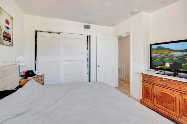 bedroom with a closet and light tile floors