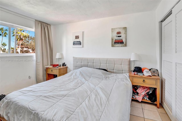 bedroom with light tile floors and a closet