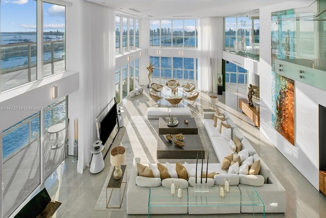 tiled living room featuring expansive windows and a high ceiling