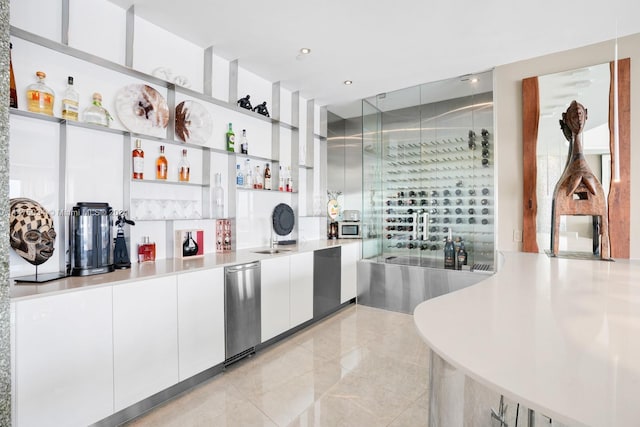 kitchen with white cabinets, dishwashing machine, light tile floors, and stainless steel dishwasher