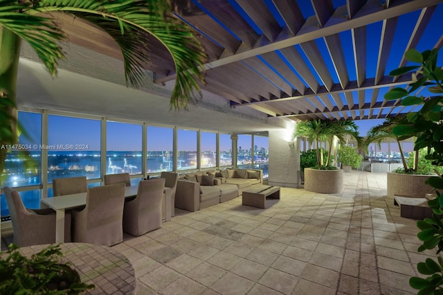 patio terrace at dusk featuring outdoor lounge area, a pergola, and a water view